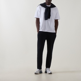 Model wearing Arne navy sweatpants, styled with a white T-shirt, black scarf and grey trainers.