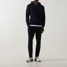 Model wearing Arne navy cotton-blend sweatpants, styled with matching navy hoodie, white T-shirt and grey trainers.