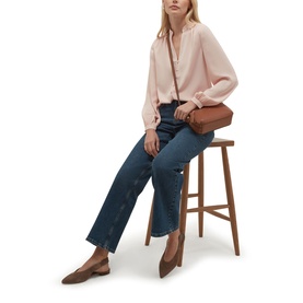 Model wearing Hobbs blush pink blouse with wide-leg dark denim jeans, styled with a tan crossbody bag and brown pointed flats.