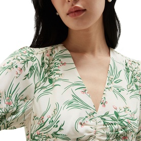 Model wearing Hobbs ivory multi floral print dress with V-neckline and puff sleeves, styled with pearl earrings