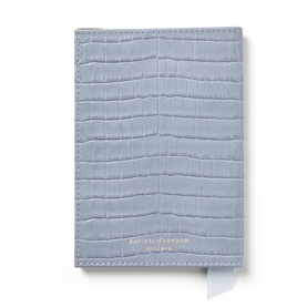 Aspinal of London sky blue croc-embossed leather passport cover with silver logo detail and ribbon page marker.