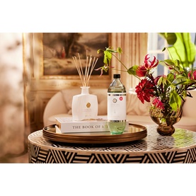 Rituals Royal Tea Refill Fragrance Sticks displayed on a decorative tray beside a reed diffuser, flowers and a book in a styled home setting.