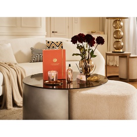 Rituals Suede Vanilla Home Fragrance Set styled on a coffee table with dark red roses, including candle, diffuser and gift box.