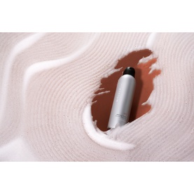 Rituals Sport Shower Foam silver aerosol bottle nestled in a swirl of white foam with a brown liquid pool beneath