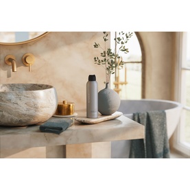 Rituals Sport Shower Foam bottle styled in a marble bathroom with grey vase, eucalyptus stems, and gold tap fittings.