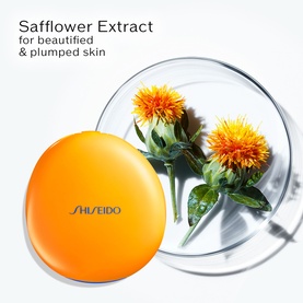 Shiseido Tanning Compact Foundation SPF10 Refill, orange compact beside safflower blooms highlighting the key extract ingredient