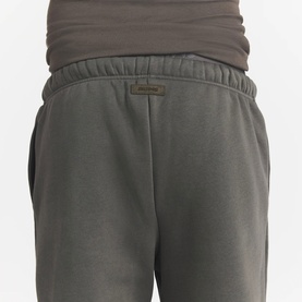 Model wearing Skims dark brown fleece joggers, close-up of elasticated waistband and back pocket detail