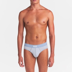 Model wearing Skims Briefs 3Pk in Nimbus Multi, light blue brief with contrast waistband shown front-facing.