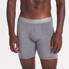 Model wearing Skims Boxers 3Pk in Iris Heather Multi, grey marl mid-length boxer briefs with branded elasticated waistband.