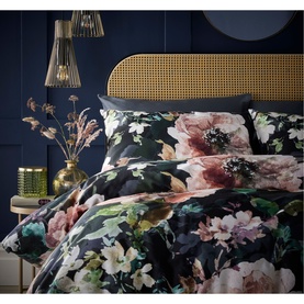 Vantona Bea Duvet Set in multi, dark floral print with pink and blush blooms on navy, styled on a double bed with rattan headboard.