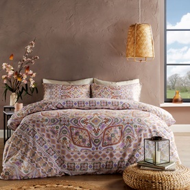 Vantona Kizzi Mandala Duvet Set in multi, featuring ornate paisley and mandala print in warm pink, purple and gold tones, styled on a double bed.