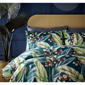 Vantona Twilight Leaves Duvet Set in multi, tropical leaf print in teal, green and rust tones, styled on a double bed with rattan headboard.