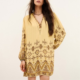 Model wearing Bash yellow mini dress with long sleeves, V-neck, and ornate brown and gold embroidered boho pattern throughout.