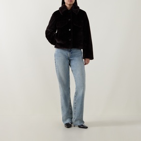 Model wearing Aligne brown faux fur jacket with button front, styled with light blue wide-leg jeans and black flat shoes.