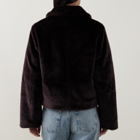 Model wearing Aligne brown faux fur jacket, rear view, styled with light blue jeans