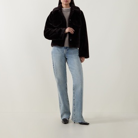 Model wearing Aligne brown faux fur jacket with light wash straight-leg jeans and black flats