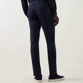 Model wearing Boggi Milano Garment-Dyed Trousers in navy, rear view, styled with a navy shirt and cream loafers