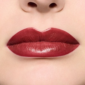 MAC Lustreglass Sheer-Shine Lipstick in Roan of Arc worn on lips, showing deep red sheer-shine finish