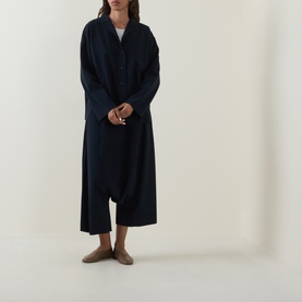Model wearing Oska Single-Breasted Blazer in navy, longline silhouette with notch lapel, styled with wide-leg trousers and flat shoes.