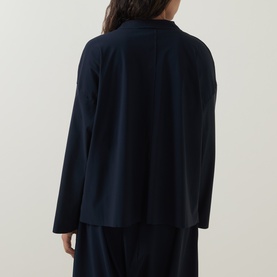 Model wearing Oska Single-Breasted Blazer in navy, rear view showing dropped shoulders, long sleeves, rear vent and fluid silhouette, styled with