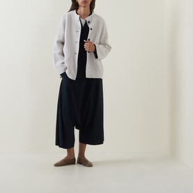 Model wearing Oska Single-Breasted Blazer in Navy, fluid silhouette with front buttons, styled with wide-leg trousers and flat shoes.
