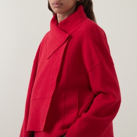 Model wearing Oska scarlet wool jacket with wide lapel collar and relaxed oversized silhouette, cropped front view