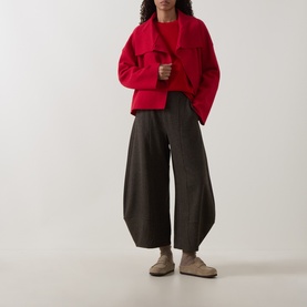 Model wearing Oska Rib-Knit Sweater in Scarlet with wide-leg dark trousers and beige suede loafers