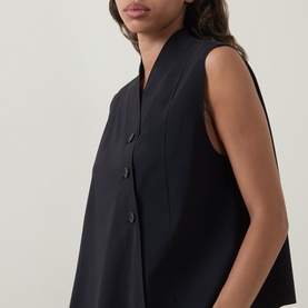 Model wearing Oska black sleeveless top with V-neckline and button-front detail, relaxed fit in polyamide blend fabric.