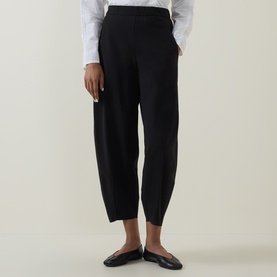 Model wearing Oska Straight Cropped Trousers in black, mid-rise with tapered hems, styled with a white shirt and black flat mules.