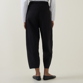 Model wearing Oska Straight Cropped Trousers in black, styled with a white shirt and flat black shoes, rear view.