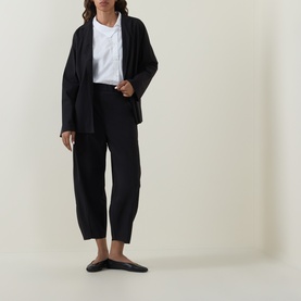 Model wearing Oska Straight Cropped Trousers in black with a black blazer, white top and black flat mules.