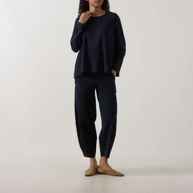 Model wearing Oska Straight Cropped Trousers in navy, styled with a matching navy long-sleeve top and tan flat shoes.