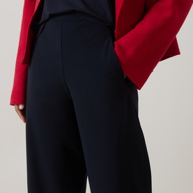 Model wearing Oska Straight Cropped Trousers in navy, mid-rise with side pockets, styled with a red jacket.