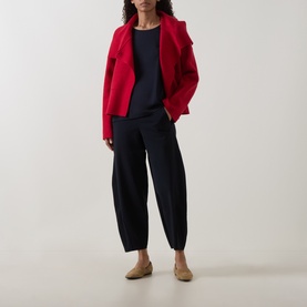 Model wearing Oska Straight Cropped Trousers in navy, styled with a red blazer and navy top, flat tan shoes.