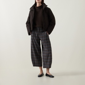 Model wearing Oska Choco check wide-leg trousers with dark puffer jacket and black ballet flats.
