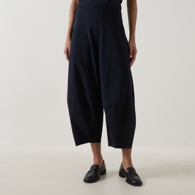 Model wearing Oska Wide Cropped Trousers in navy, wide-leg silhouette with elasticated waistband, styled with black loafers
