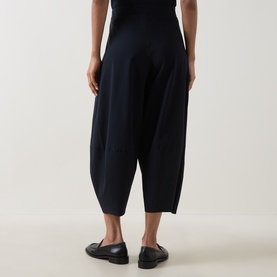 Model wearing Oska Wide Cropped Trousers in navy, wide-leg silhouette with elasticated waistband, styled with black loafers