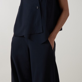 Model wearing Oska Wide Cropped Trousers in navy, wide-leg silhouette with clean hems, styled with matching navy sleeveless top.
