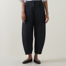 Model wearing Oska Wide Leg Cropped Trousers in black, tapered barrel-leg silhouette, styled with black ballet flats and white top.
