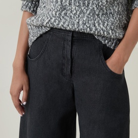 Model wearing Oska Wide Leg Cropped Trousers in black with wide-leg silhouette and elasticated waistband, styled with a grey knit top.