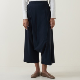 Model wearing Oska Draped Wide Cropped Trousers in navy, featuring wide-leg silhouette, draped front detail and cropped length, styled with a white