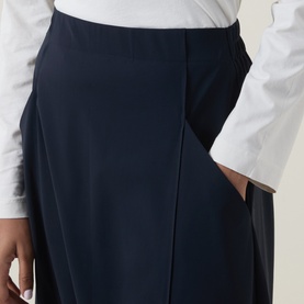 Model wearing Oska Draped Wide Cropped Trousers in navy, showing elasticated waistband, draped front panel and side pocket detail