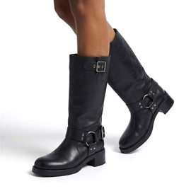 Model wearing Steve Madden black leather knee-high biker boots with silver buckle and harness ring detail, block heel