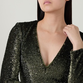 Model wearing Bardot khaki sequin dress, close-up of V-neckline and long sleeve detail with all-over sequin embellishment.