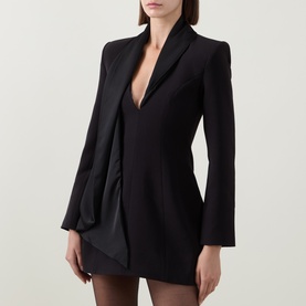 Model wearing Bardot black mini dress with deep V-neckline, structured shoulders, long sleeves and draped side detail