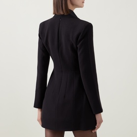 Model wearing Bardot black dress, rear view showing structured shoulders, fitted waist, and mini length