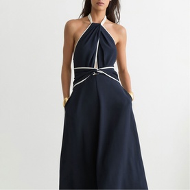 Model wearing Reiss blue halterneck midi dress with white contrast trim detailing and wrap-effect waist tie