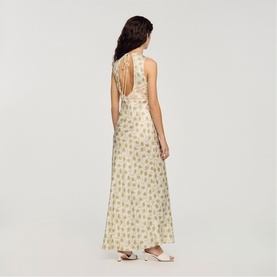 Model wearing Sandro Womens French Dress in olive/ecru floral print, open back with tie detail, maxi length, back view.