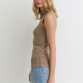 Model wearing Reiss dark neutral sleeveless ribbed roll-neck top with ruched side detail, styled with light blue jeans