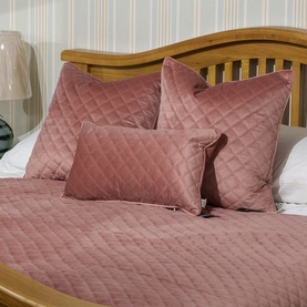 Fever + Hue Velvet Quilted Cushion in Rose Quartz, diamond-stitched, styled with matching bedspread on a wooden bed